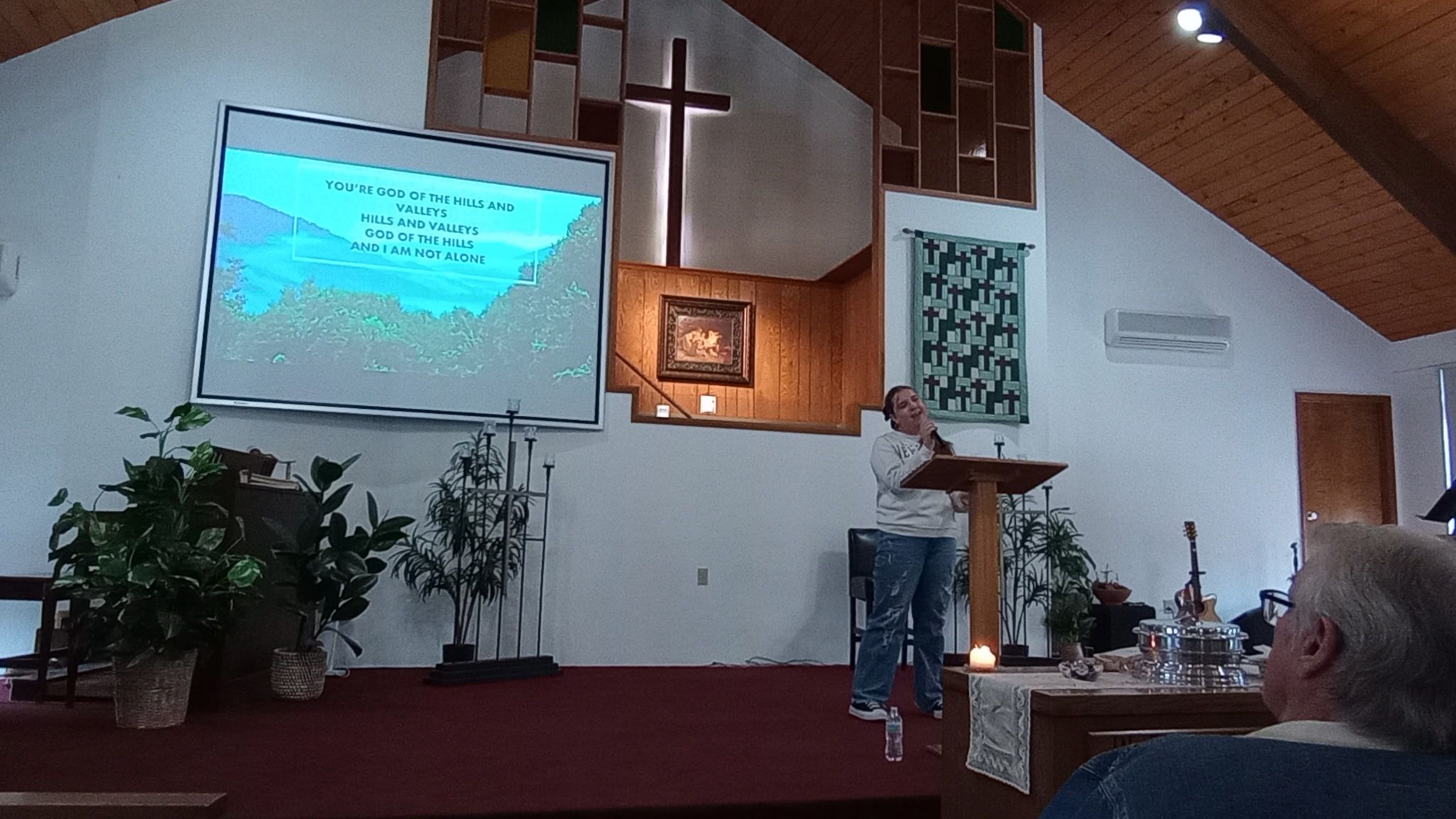 Worship service with projection screen and wooden cross